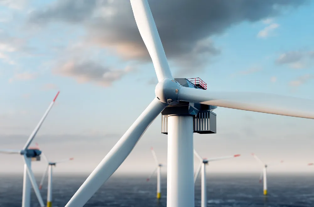 ChatGPT said: Alt text: Offshore wind turbines generating renewable energy at sea during early evening. The image shows multiple large white wind turbines with red-tipped blades against a blue sky with light clouds, highlighting sustainable power sources in the UK.